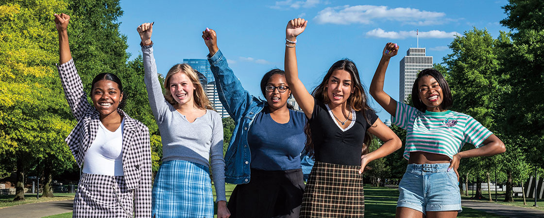 Five women with their fists in the air