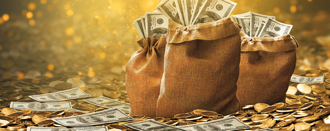 Three burlap bags filled with cash sit among scattered bills and gold coins